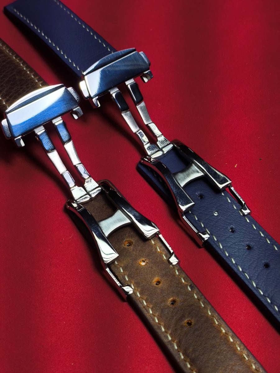 Fechos deployant de duas pulseiras sobre veludo vermelho